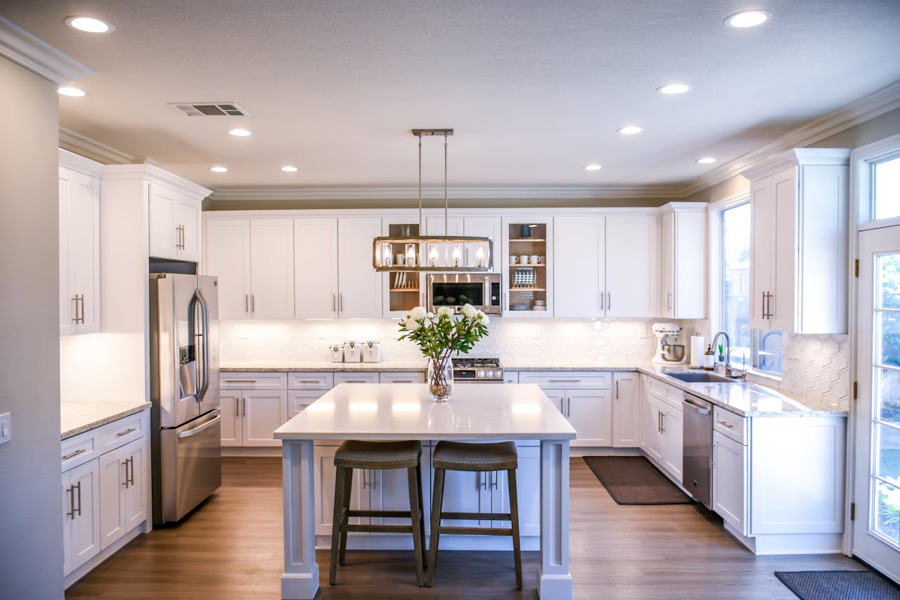 Spacious and elegant kitchen featuring white cabinetry, island, and stainless steel appliances.